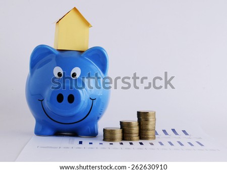 House paper on piggy bank and coins for loans concept