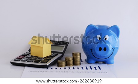 House paper on Calculator and coins and piggy bank for home Loans concept