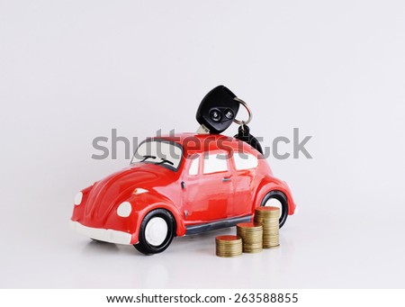 Car key into Car bank and coins stack on white background for loans concept