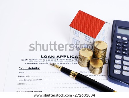 close up for fountain pen with loan application form and coins stack and paper house and calculator for Mortgage loan concept