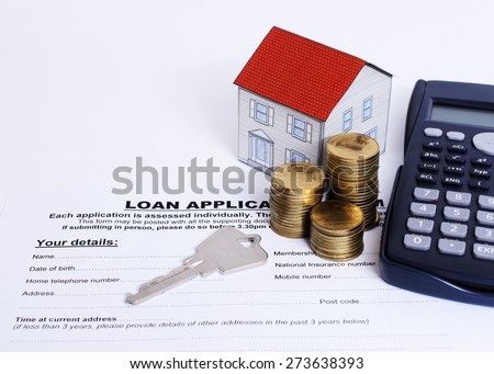 Home key and coins stack and paper house and calculator on Loan application form for loan concept
