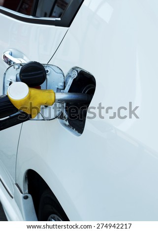 Close up of Fuel nozzle into fuel tank for car refueling