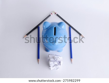 Home loans concept with pencils and piggy bank and paper on white background