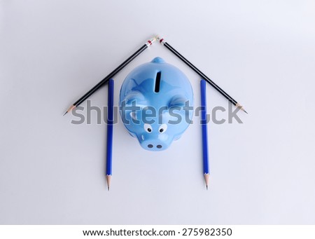 Blue piggy bank and pencils for mortgage loans concept
