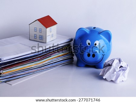 Mortgage loans concept with piggy bank and paper house on bill payment stacks