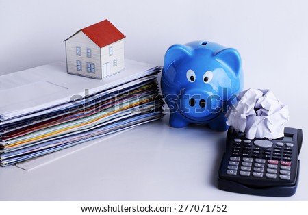 Bill payment and paper house and piggy bank and calculator for mortgage loans concept