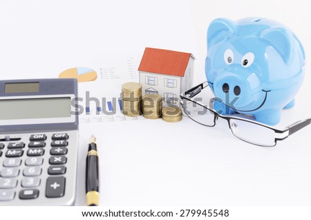 Saving money plan with piggy bank and paper house and eyeglasses and calculator and fountain pen