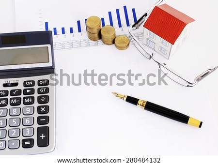 Mortgage loans concept with Fountain pen and paper house and coins stack and eyeglasses and calculator on report document