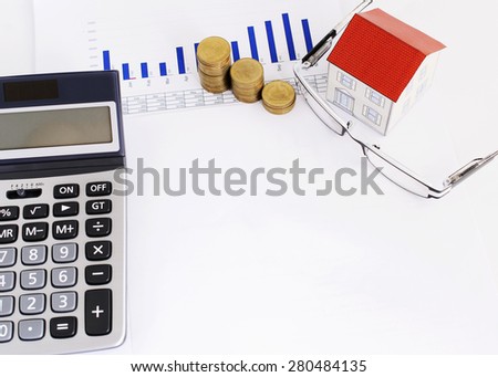 Mortgage loans concept with paper house and coins stack and eyeglasses and calculator and blank area for your texts