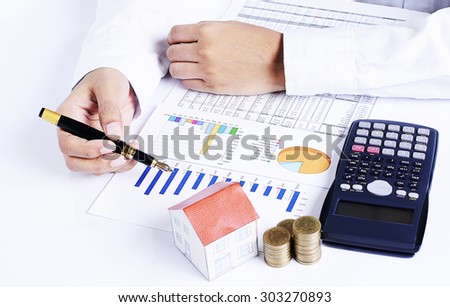 Front views of Hand people holding fountain pen on business chart and calculator with coins stack and house paper for loans concept