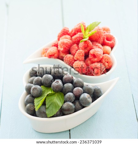 Delicious fresh berries on blue wooden background
