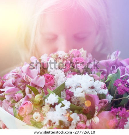 Portrait of a  little girl  smelling the flowers.