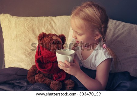 Ill girl with toy bear in the bed