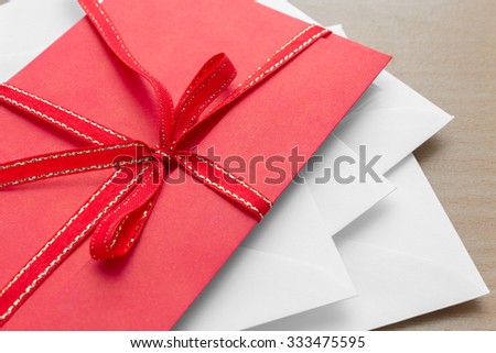 pile of envelopes with red envelope on top