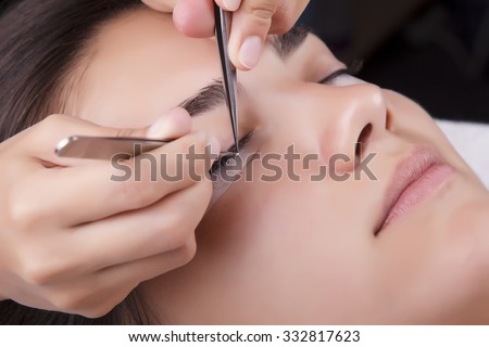 Japanese eyelash extensions. Long eyelashes. Beautiful dark-haired girl lies on a couch in the office of the master eyelash.