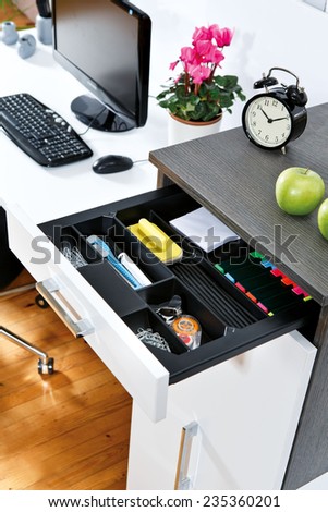 Office supplies in open desk drawer