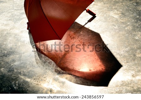 a red umbrella on wet metal plates