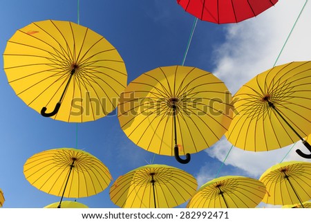Collection of multi colored umbrellas hanging up in an open position over a street