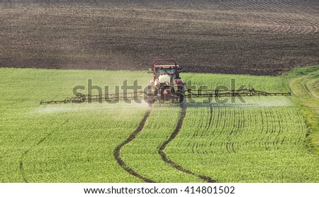 Tractor pours fertilizer in agriculture field