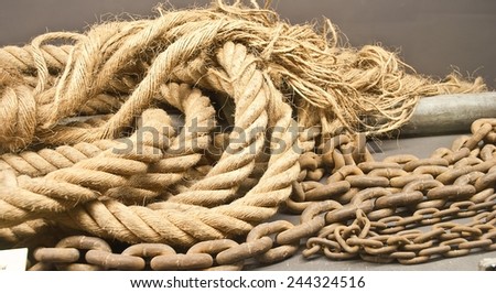 Manila rope and chain at wooden deck under soft light, grunge processing image