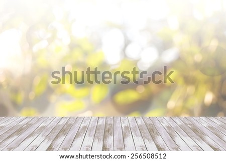 Blurred abstract background of looked-up tree in yellow tone with wooden floor