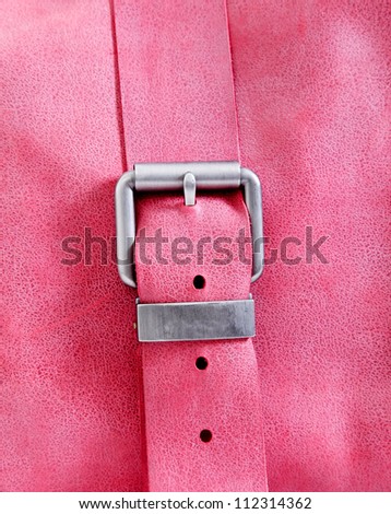 belt with silver buckle pink background