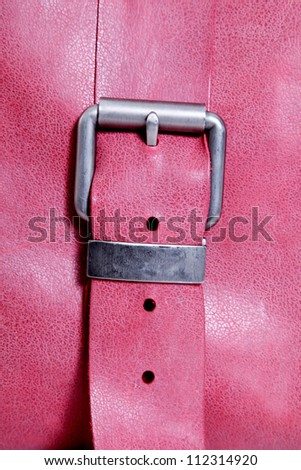 belt with silver buckle pink background