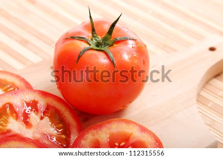 big tomato and tomatoes in half natural background