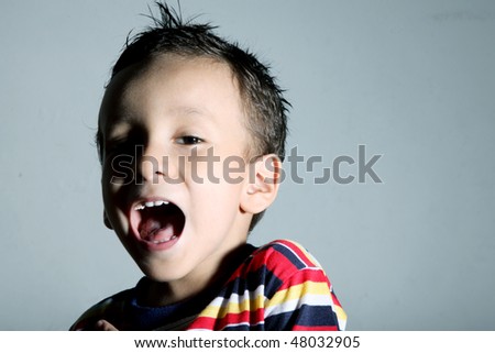 Child expressing positivity over gray background. Screaming