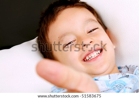 Boy smiling with his hand extended to the camera. Concept: Positive attitude and happiness