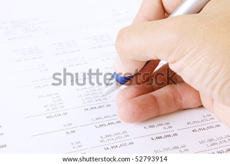 Hand writing with a pen reviewing the numbers