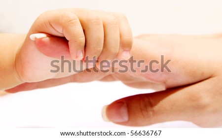 Hand of a baby taking his mother\'s hand. Concepts: Love, family and unit