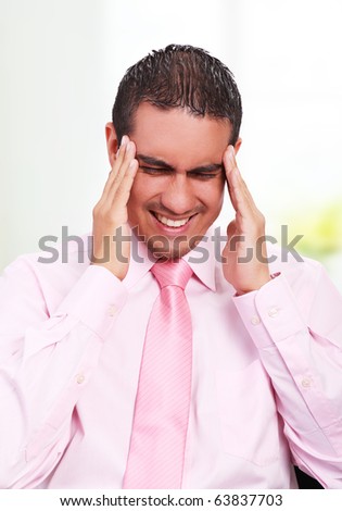 Young businessman with headache, expressing pain with his face