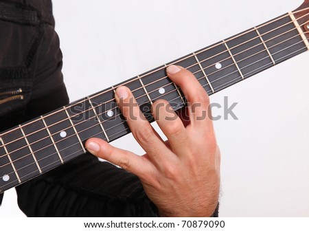 Hand holding a guitar over white background
