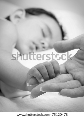 Baby sleeping take the hand of her mother in black and white