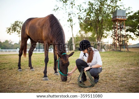 Young asian woman feeding a horse
