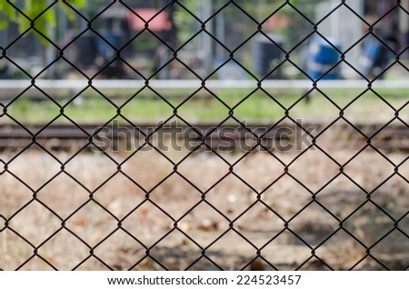 Metal mesh wire fence with blur factory background