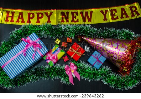 happy New Year message and  gift box on wooden background.