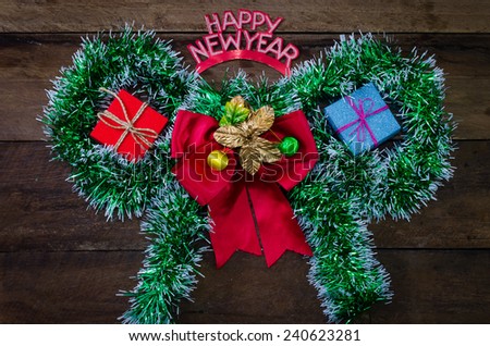 happy New Year message and gift box on wooden background.