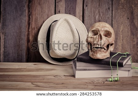 still life - skull on books and hat on wooden table
