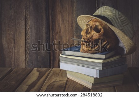 Still life skull . Cap machine weave and books on wooden background
