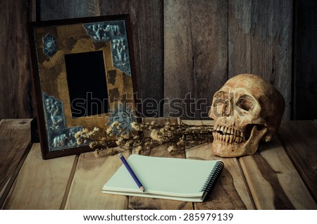 Still life skull picture frames, vases, dried rose notebook concept frequent memories