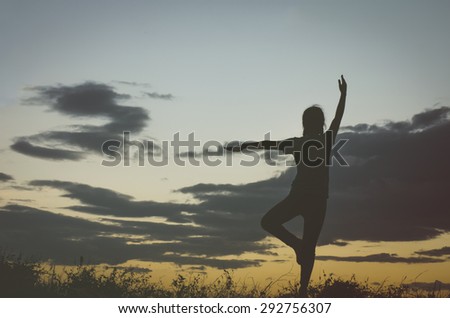 Silhouette of a woman yoga exercise when the sun is about to set.