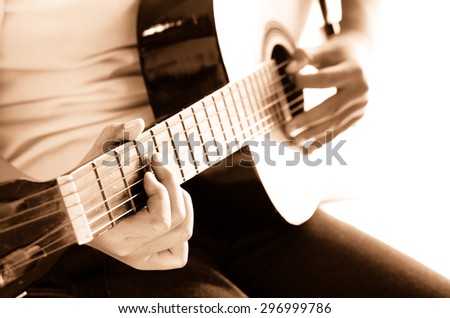 Girl playing guitar,hand focus sepia tone.