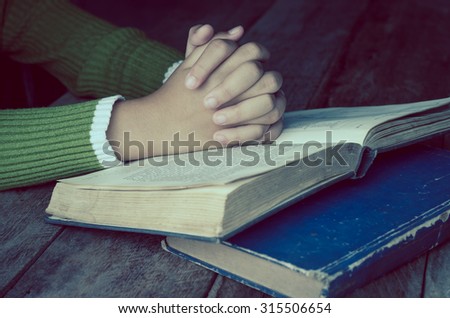Hands with Bible on wood table