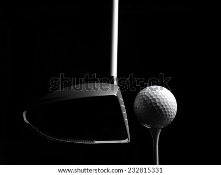 Teeing off in a game of golf with a golf ball and golf tee, isolated on black with copy space.