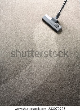 Vacuuming a carpet with a hoover