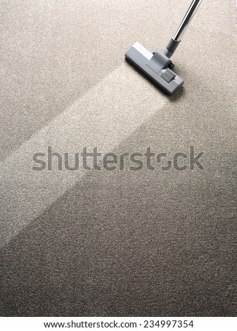 Vacuum cleaner on a carpet with an extra clean strip for copy space