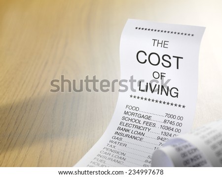 Cost of living shopping list showing the expense of home finance with copy space on wooden background