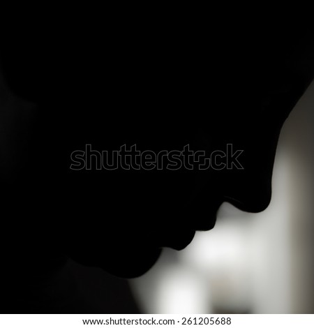 A profile of a woman emerges from the darkness.